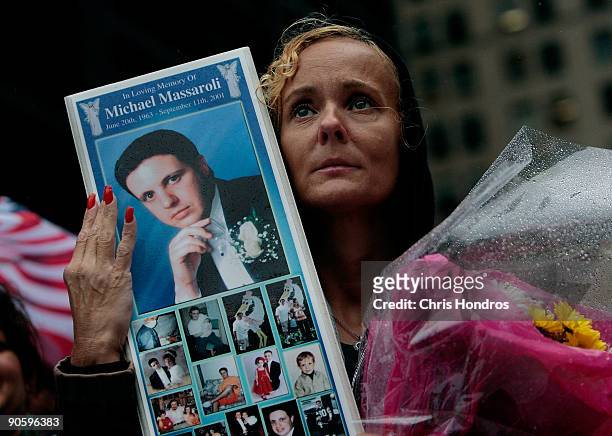 Diane Massaroli , of Staten Island, New York holds up a picture of her late husband, Michael Massaroli, who worked at Cantor Fitzgerald at the World...