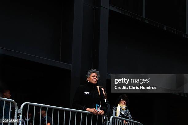 Woman standing on the edge of the ceremony holds a picture of a loved one as she listens to the reading of the names as people pay their respects at...