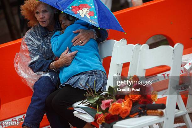 Woman and child who lost a family member hold onto each other as the names of the victims are read at Ground Zero during a 9/11 memorial ceremony on...