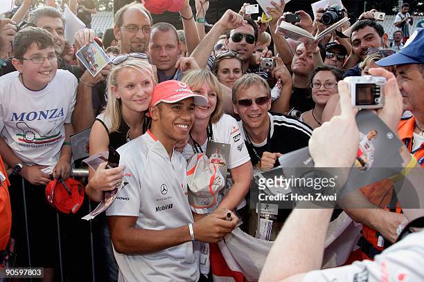 Lewis Hamilton of Great Britain and McLaren Mercedes signs autographs for fans following practice for the Italian Formula One Grand Prix at the...