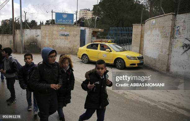 Palestinian boys walk past a United Nations' run school in the Qalandia refugee camp near Ramallah in the West Bank, on January 17, 2018 after the...