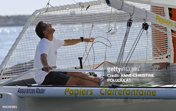 Skipper Michel Desjoyeaux holds the helm on his catamaran during a sailing event on the eve of the launching of the 20th Trophee Clairefontaine...