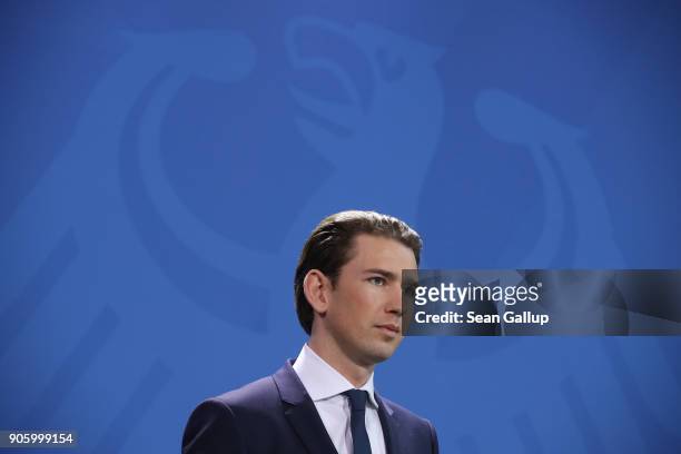 New Austrian Chancellor Sebastian Kurz and German Chancellor Angela Merkel speak to the media in front of the German federal eagle following talks at...