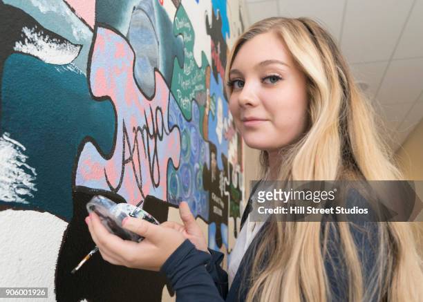 portrait of caucasian girl mixing paint for wall mural in school - teen creativity stock pictures, royalty-free photos & images