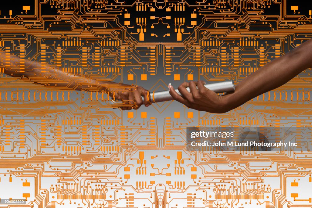 Hands of women passing baton on circuit board