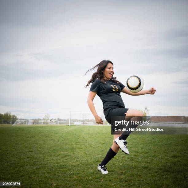 smiling woman juggling soccer ball on thigh - benton bildbanksfoton och bilder