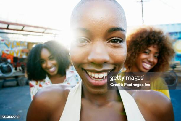 friends smiling behind bald woman outdoors - hair loss in woman stock pictures, royalty-free photos & images