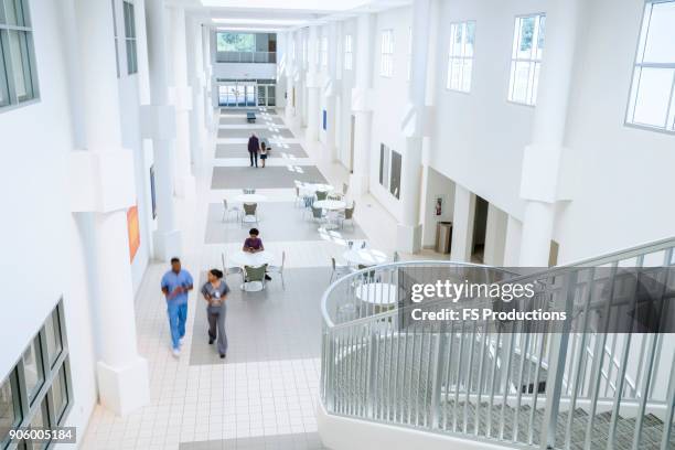 nurses walking in lobby - medical lobby stock pictures, royalty-free photos & images