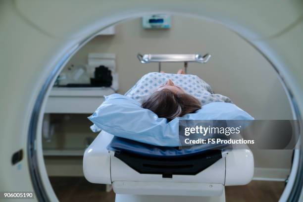 caucasian patient laying on scanner table - ct scanner stockfoto's en -beelden