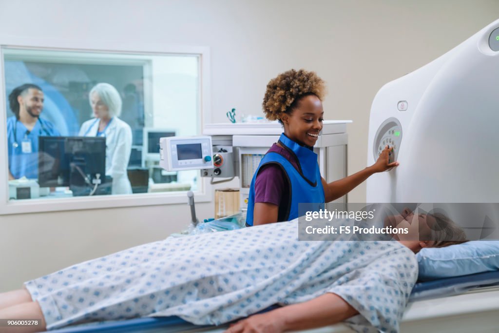 Smiling technician preparing scanner for patient