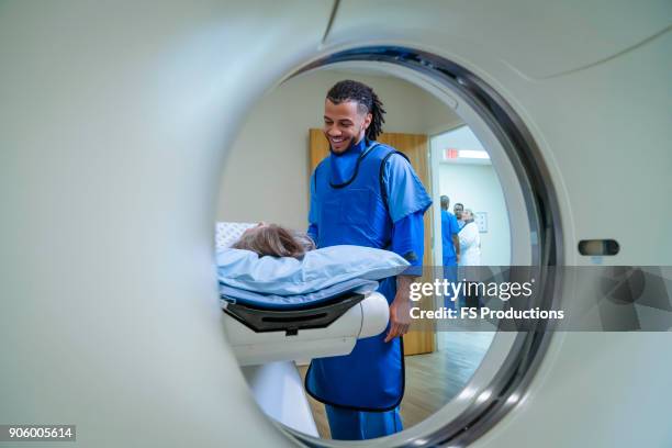 technician talking to patient near scanner - cat scan stock pictures, royalty-free photos & images