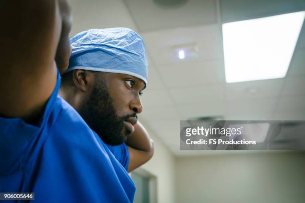 black doctor wearing surgical cap - chirurgenkappe stock-fotos und bilder