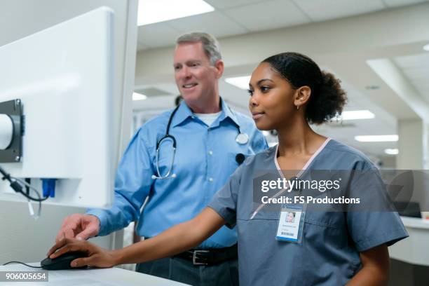 doctor and nurse using computer - nurse looking at computer stock pictures, royalty-free photos & images