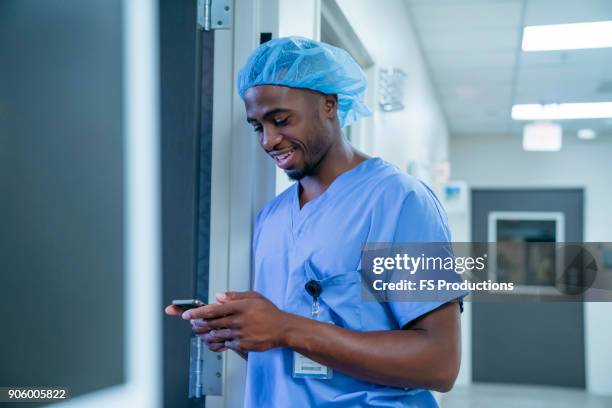 black nurse texting on cell phone - doctor smartphone stock pictures, royalty-free photos & images