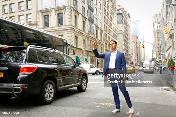 caucasian businessman standing in street hailing taxi - hail stock-fotos und bilder