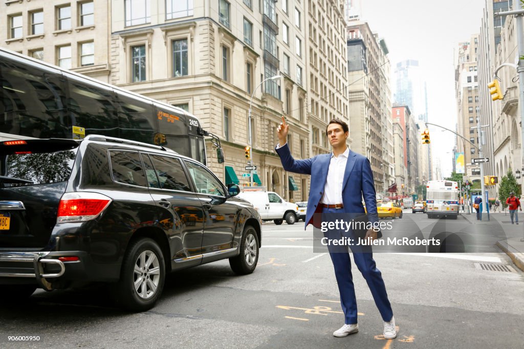 Caucasian businessman standing in street hailing taxi
