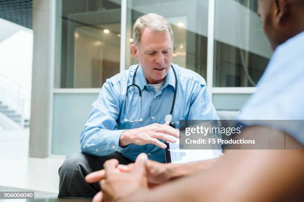 doctor and nurse discussing digital tablet - hospital exterior stock pictures, royalty-free photos & images