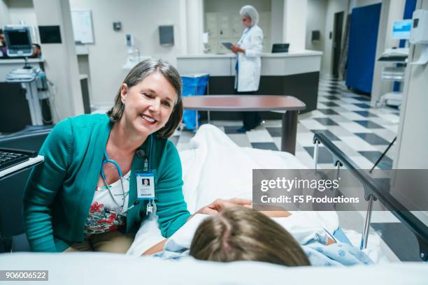 caucasian doctor comforting patient in hospital bed - rapporto medico paziente foto e immagini stock
