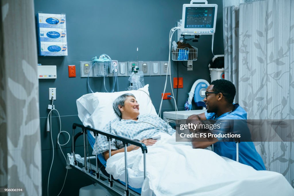 Nurse talking to patient in hospital bed