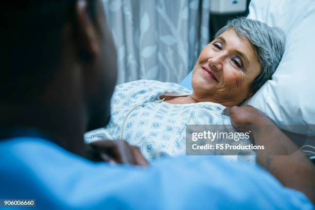 nurse talking to patient in hospital bed - good news stock pictures, royalty-free photos & images