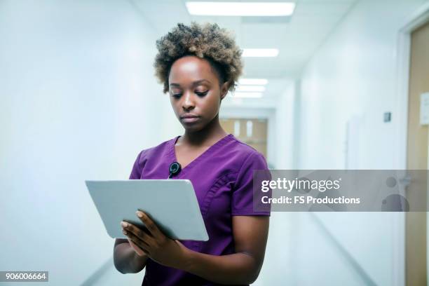 black nurse using digital tablet in hospital - tablet close up real copyspace stock pictures, royalty-free photos & images