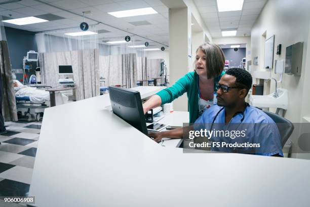 doctor and nurse using computer - posto de enfermagem imagens e fotografias de stock
