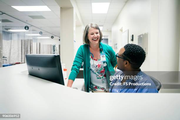 doctor and nurse laughing near computer - hospital teamwork stock pictures, royalty-free photos & images