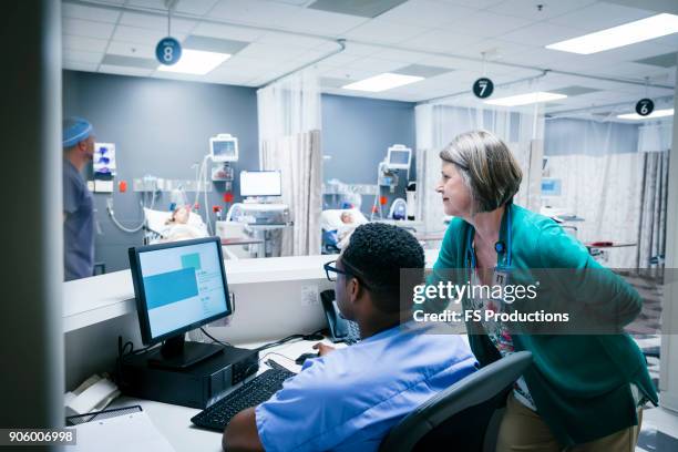 doctor and nurse using computer - ナースステーション ストックフォトと画像