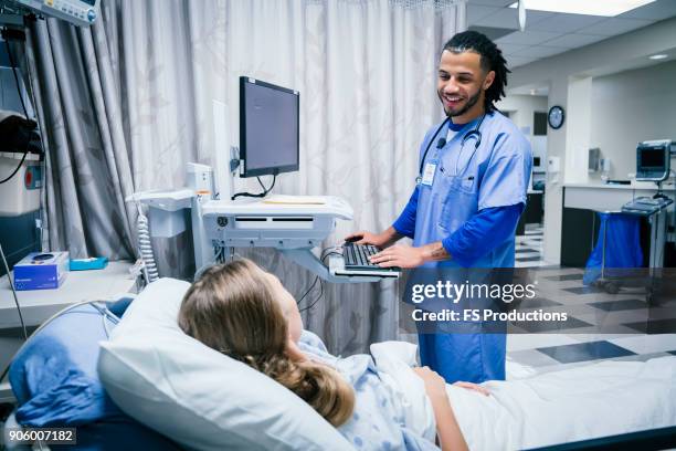 nurse talking to patient in hospital bed - serviço de urgência imagens e fotografias de stock