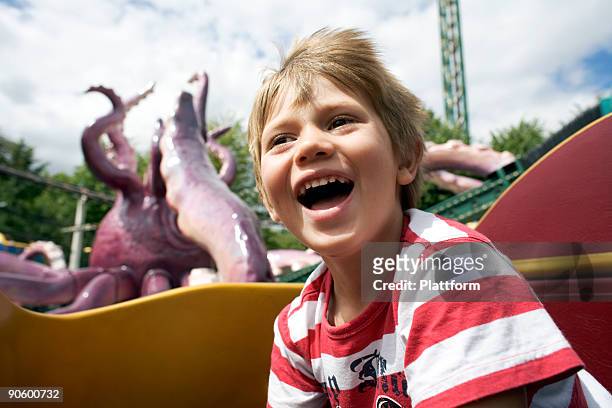 a boy in an amusement park denmark. - achterbahn stock-fotos und bilder