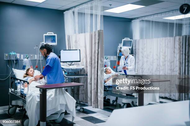 doctor and nurse with patients in hospital - spoedeisende hulp stockfoto's en -beelden