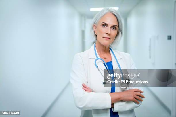 portrait of confident caucasian doctor in hospital - doctor attitude stock pictures, royalty-free photos & images