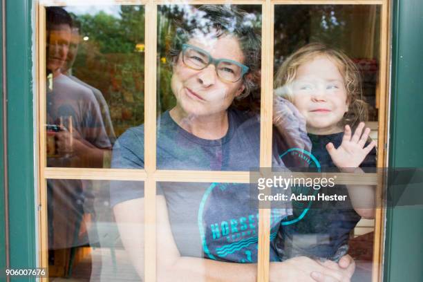 Caucasian mother and son making a face in door window