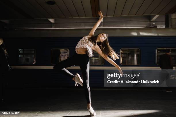 caucasian woman dancing near train - urban ballet stockfoto's en -beelden