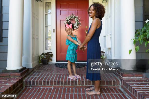 portrait of smiling mixed race mother and daughter on front stoop - family smiling at front door stock pictures, royalty-free photos & images