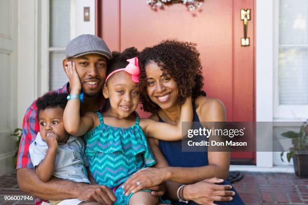 portrait of smiling mixed race family sitting on front stoop - proud father stock pictures, royalty-free photos & images