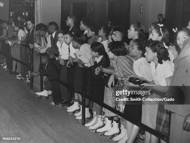 African-American children wearing roller skates, leaning on railing during entertainment event, Chicago, Illinois, USA, 1935. From the New York...