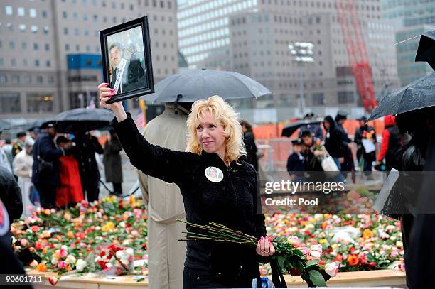 Woman holds an image of a family member as people stand in the rain and gather at Ground Zero during a 9/11 memorial ceremony on September 11, 2009...