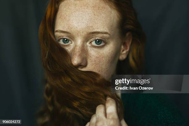 caucasian woman covering mouth with hair - tímido imagens e fotografias de stock