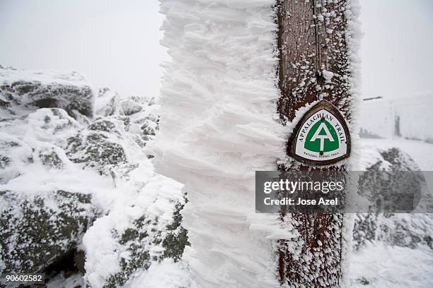 a small, green snow covered sign points to the appalachian trail  in the white mountains of new hamp - appalachian trail stock pictures, royalty-free photos & images