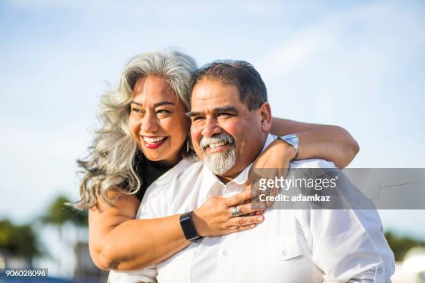 senior mexican couple piggyback at the beach - fat mexican man stock pictures, royalty-free photos & images