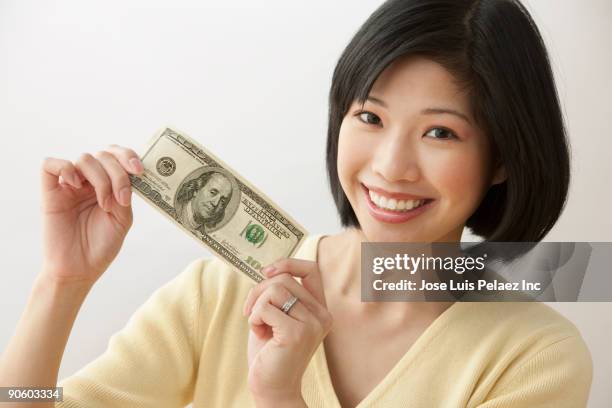 filipino woman holding one hundred dollar bill - american one hundred dollar bill stock pictures, royalty-free photos & images