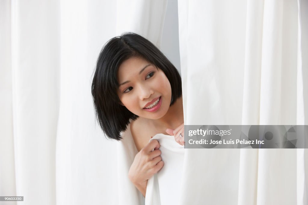 Filipino woman peering out of dressing room