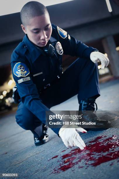 asian policeman examining blood on ground - criminal justice concept stock pictures, royalty-free photos & images