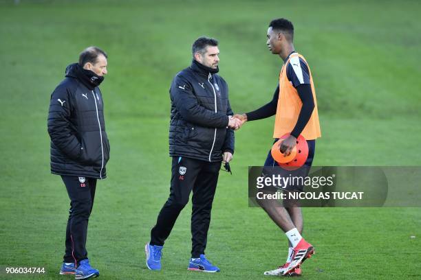 Bordeaux's French head coach Jocelyn Gourvennec shakes hand with a player during a training session on January 17, 2018 at the Haillan training...