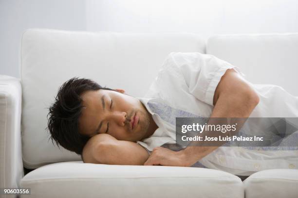 asian man sleeping on sofa - lying on side stock pictures, royalty-free photos & images
