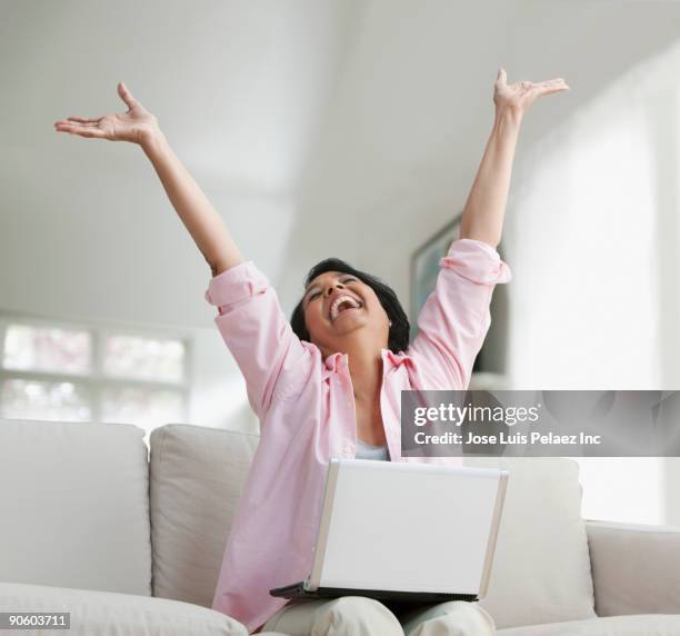 african woman holding laptop with arms raised - exhilaration stock pictures, royalty-free photos & images