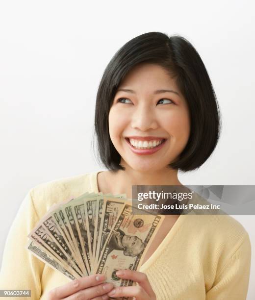 filipino woman holding money and smiling - 50 dollar bill stock pictures, royalty-free photos & images