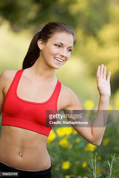 hispanic woman in sports bra waving - belly ring stock pictures, royalty-free photos & images
