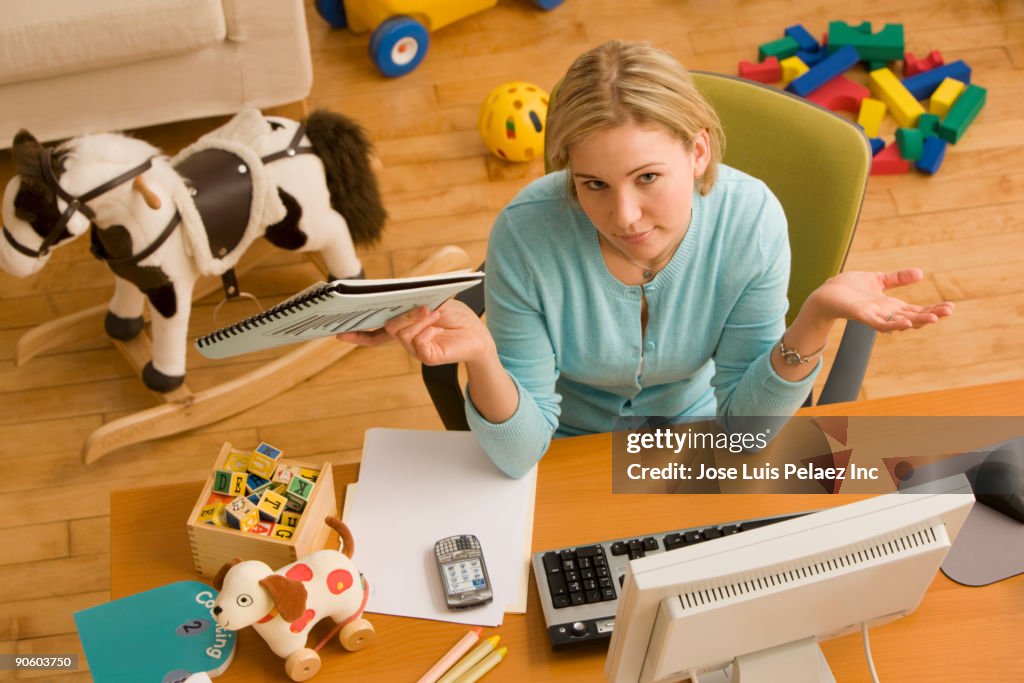 Hispanic woman gesturing at desk surrounded by toys